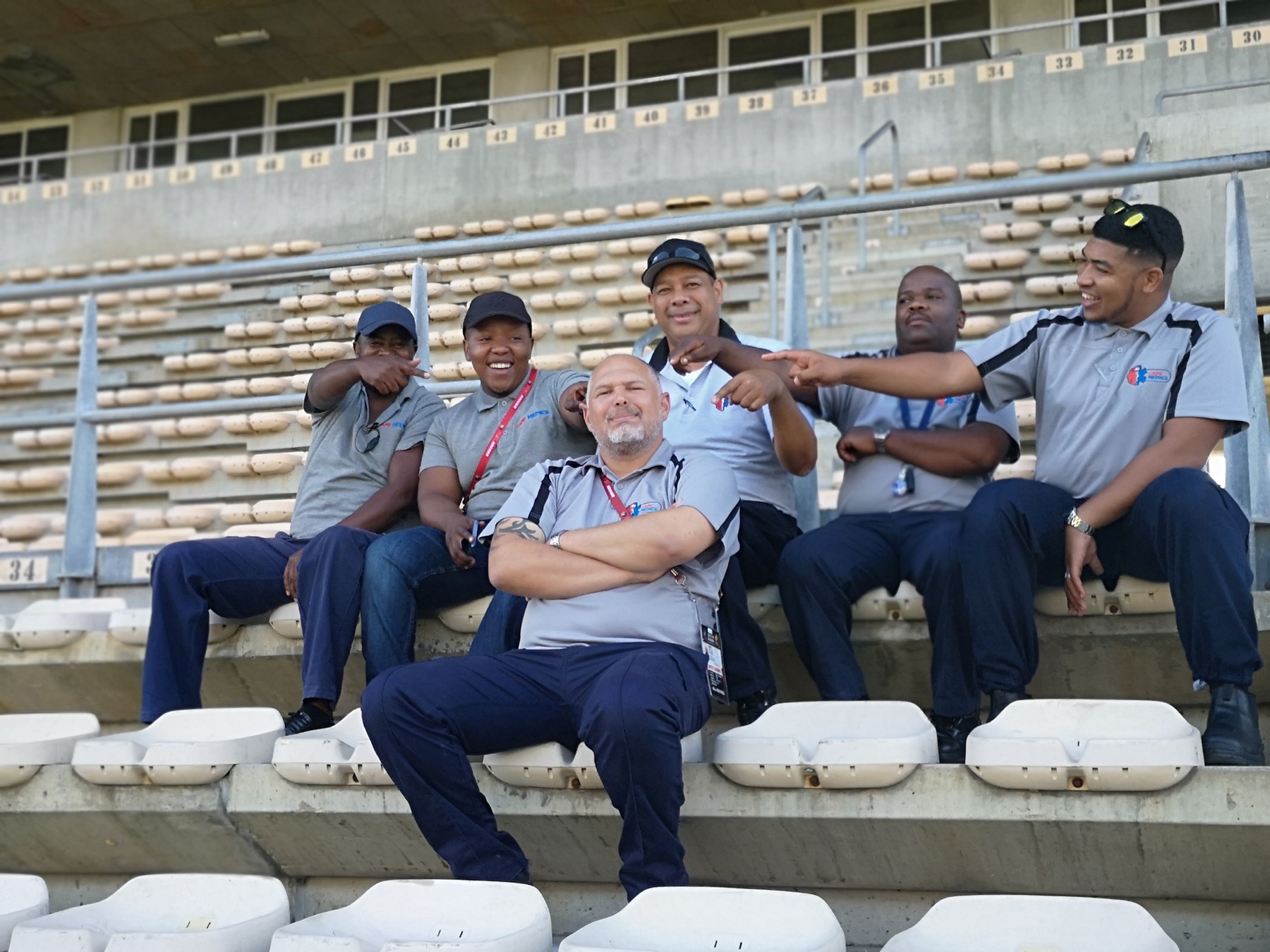 Six Cape Medics team members seated in stadium stands